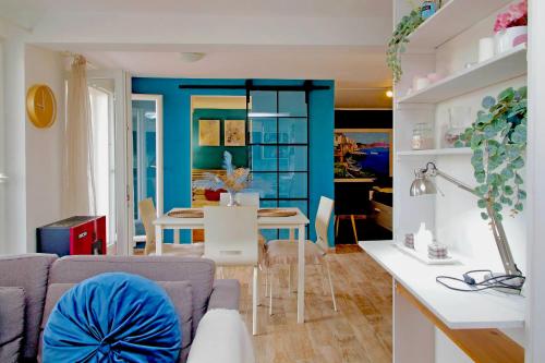 a living room and dining room with a blue wall at The Attic in Civitavecchia