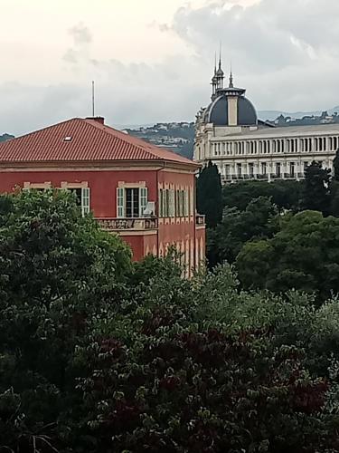 un bâtiment rouge avec un bâtiment en arrière-plan dans l'établissement Nice centre- small pied-a-terre near beaches, à Nice