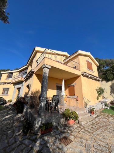 a large yellow house with a staircase in front of it at Venti di Vacanza - Levante & Grecale in Olbia