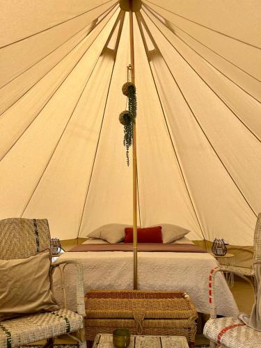 une chambre avec un lit dans une tente dans l'établissement Chambre au jardin Tente de charme, à Éguzon-Chantôme