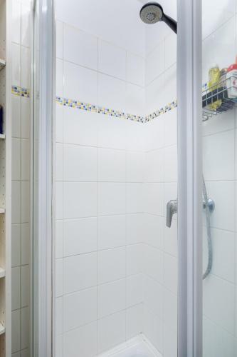 une douche avec une porte vitrée dans une salle de bain dans l'établissement Chic 1BD Apartment with Balcony Picpus, à Paris