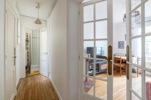 un couloir avec une porte menant à une salle à manger dans l'établissement Chic 1BD Apartment with Balcony Picpus, à Paris