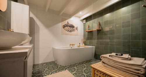 a bathroom with a bath tub and a sink at De Sleeuwijkerwaard in Sleeuwijk