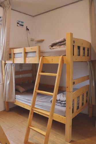 a bunk bed with a ladder in a room at 漫慢旅宿 in Xiaoliuqiu