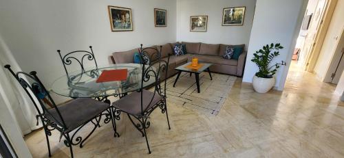 a living room with a glass table and a couch at Appartement marina hammamet in Yasmine