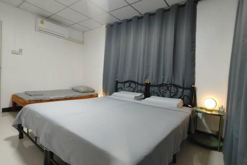 two twin beds in a room with a window at 曼谷辉煌 旺中带静 带庭院的3个房间独立别墅 in Bang Rak