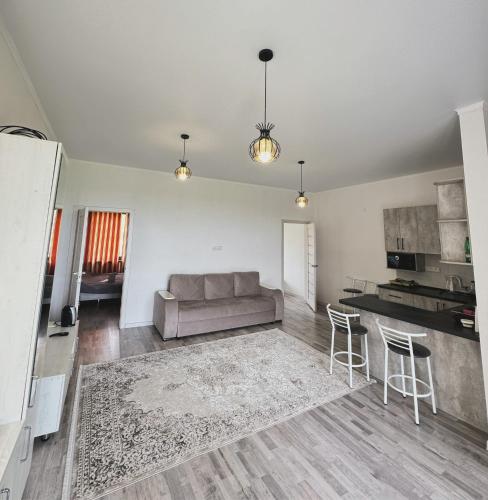 a living room with a couch and a kitchen at Simiram in Korumdy