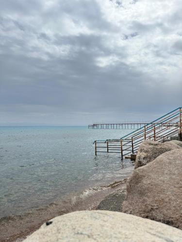 a beach with a wooden pier in the water at Simiram in Korumdy