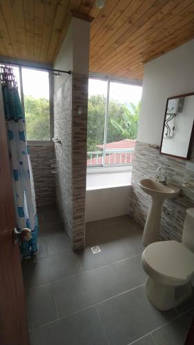 a bathroom with a shower and a toilet and a sink at El Amor Nos Une, 1habitacion, acogedor, vista a zonas verdes in Calarcá