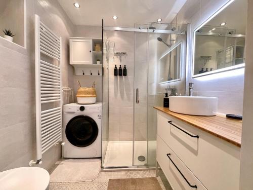 a bathroom with a washing machine and a sink at Modern Lake Como Apartment by Honey Homes in Sala Comacina