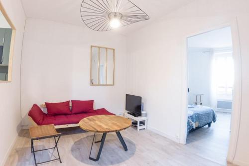 un salon avec un canapé rouge et une table dans l'établissement All shops available by foot, à Nantes