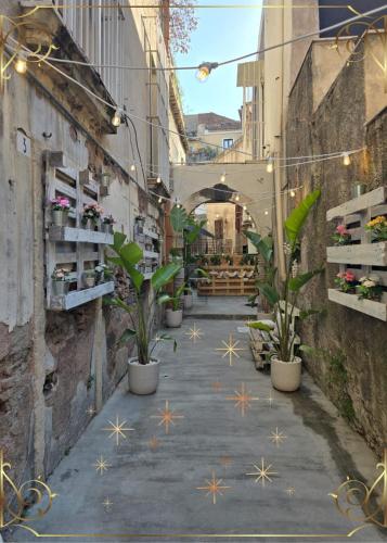 an alley with potted plants and lights in a building at Elite Apartment SPA in Catania