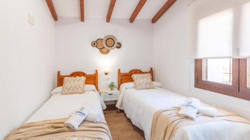 two beds in a room with white walls at Alma del Tejar Antequera La Higuera by Ruralidays in Antequera