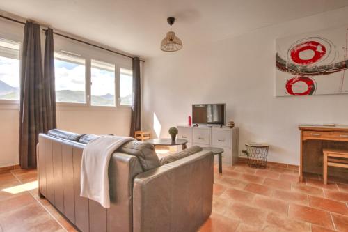 un salon avec un canapé et une table dans l'établissement Le Panoramique, à Lourdes