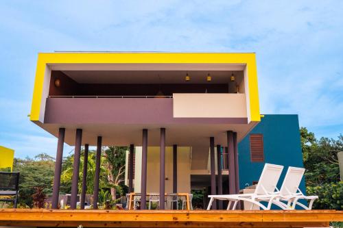 a colorful house with chairs on a deck at Naturescape Villa Bliss - Sint Michiel in Sint Michiel
