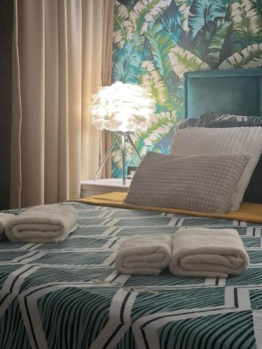 a bedroom with a bed with towels on it at Apartman Milos, privatan parking in Kraljevo