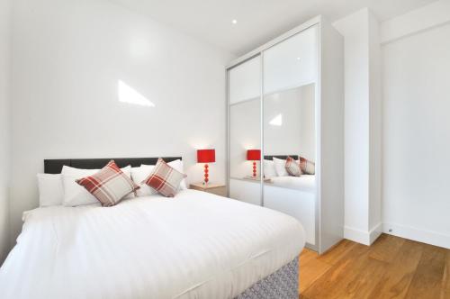 1 dormitorio blanco con 1 cama blanca grande con almohadas en Access West Kensington, en Londres