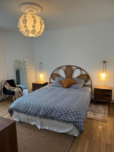 une chambre avec un lit avec une couette bleue dans l'établissement La maison du Maréchal, à Parthenay