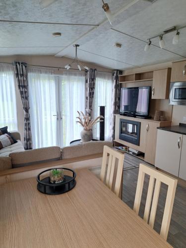 a living room with a table and a couch at Camping de Zandhorst, Chalet Victory in Wouterswoude
