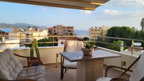 a patio with a table and chairs on a balcony at Vivere Terrace Seaside Kalamata in Faraí