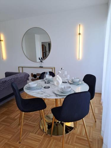a dining room table with chairs and a mirror at Appartement de standing in Créteil