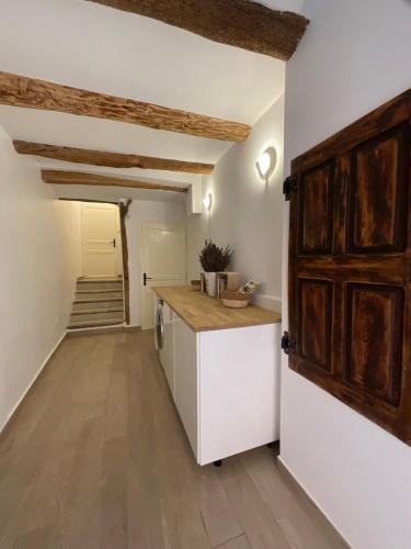 a kitchen with white walls and wooden cabinets at Zofia appartements - Duplex avec terrasse #2 in Moustiers-Sainte-Marie