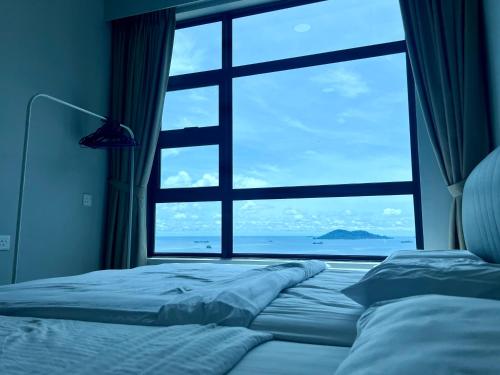 a bed in a room with a large window at JQ Unity Homestay 2 High Floor Seaview Netflix 6pax in Kota Kinabalu