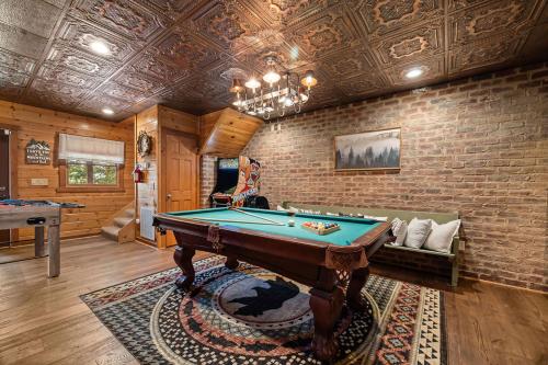 a room with a pool table and a brick wall at Mountain Paradise by Eden Crest in Sevierville