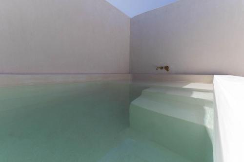 a white room with a pool of water on the floor at Suites Panamera in Tulum