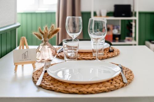 - une table avec une assiette et des verres à vin dans l'établissement Le Studio Saint-Pierre - Dax, à Dax