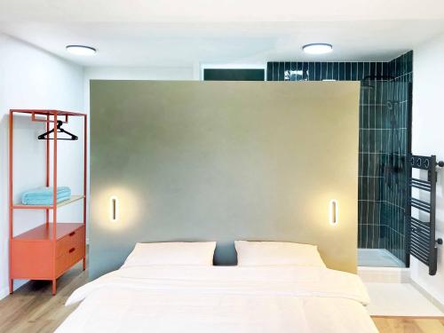 a bedroom with a white bed and a green wall at Fenêtre sur Cour - Albi Centre - Parking Privé in Albi