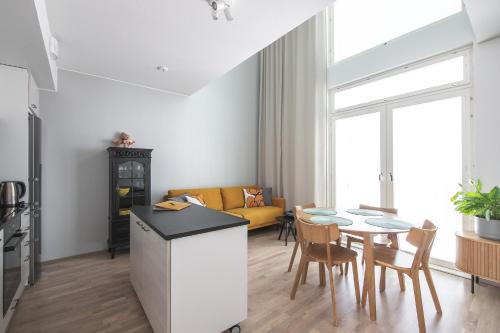 a kitchen and living room with a table and chairs at Ydinkeskustassa saunallinen huoneisto kahdessa tasossa in Kuopio