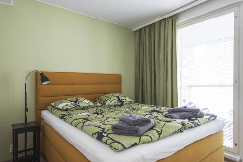 a bedroom with a bed with towels on it at Ydinkeskustassa saunallinen huoneisto kahdessa tasossa in Kuopio