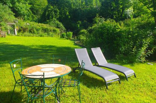 two chairs and a table in a yard at Tres Vents del Roser - grand appartement in Prats-de-Mollo-la-Preste