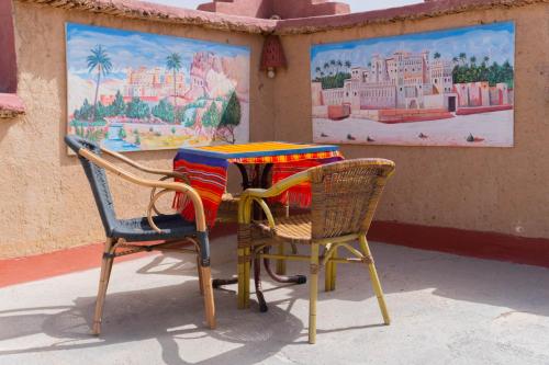 une table et deux chaises assises l'une à côté de l'autre dans l'établissement Kasbah La Datte D'or, à Skoura