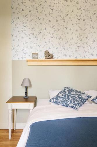a bedroom with a bed and a table with a lamp at Gîte Glycine pour 8 personnes avec sauna et bain nordique in Capian