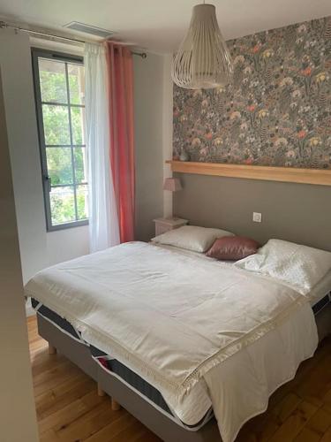 a large bed in a room with a window at Gîte Glycine pour 8 personnes avec sauna et bain nordique in Capian