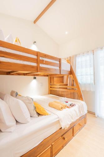 a bedroom with a bunk bed with white sheets at ไชยพล โฮมสเตย์ หมู่บ้านแม่กำปอง in Ban Pok Nai