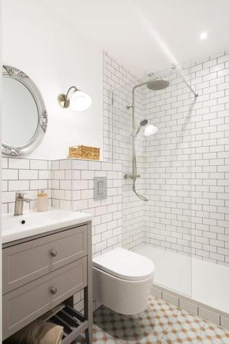 a bathroom with a shower and a toilet and a sink at Gîte Glycine pour 8 personnes avec sauna et bain nordique in Capian