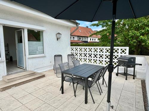 a table and chairs with an umbrella on a patio at Grosse Comfort-Ferienwohnungen Haus Bonni in Celle