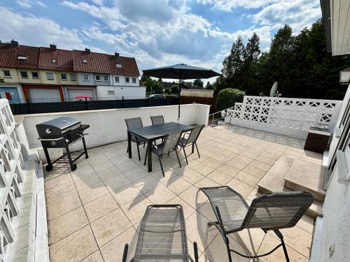 a patio with a table and chairs and a grill at Grosse Comfort-Ferienwohnungen Haus Bonni in Celle