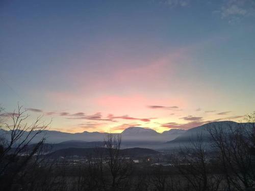 a sunset with mountains in the background and trees at Chalet confortable à Varces-Allières-et-Risset avec terrasse in Risset