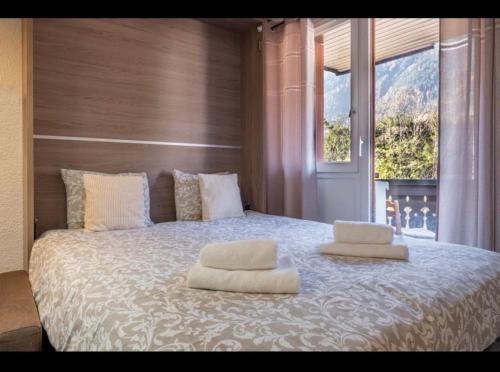 une chambre avec un grand lit avec deux oreillers dessus dans l'établissement Art Studio, à Chamonix-Mont-Blanc