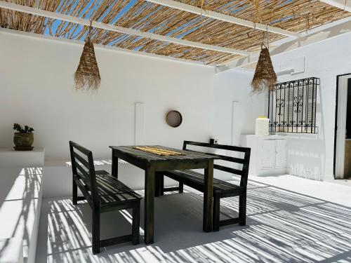 Dar almasyaf, maison bord de mer في Gabès: غرفة طعام مع طاولة سوداء وكراسي