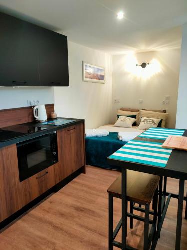 une cuisine avec une table et un salon dans l'établissement Chalet vacances avec jardin près d'Arcachon 2 personnes, à La Teste-de-Buch