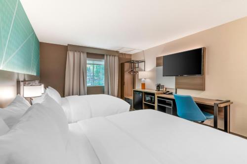 Habitación de hotel con 2 camas, escritorio y TV. en Comfort Inn & Suites Saratoga Springs, en Saratoga Springs