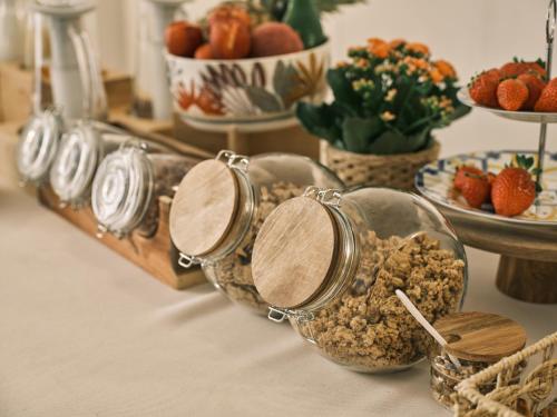 a table topped with bowls of granola and bowls of strawberries at Cifilì House of Charme in Catania