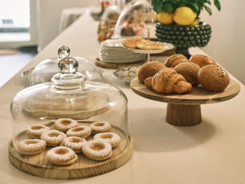 a table topped with plates of donuts and a glass jar at Cifilì House of Charme in Catania