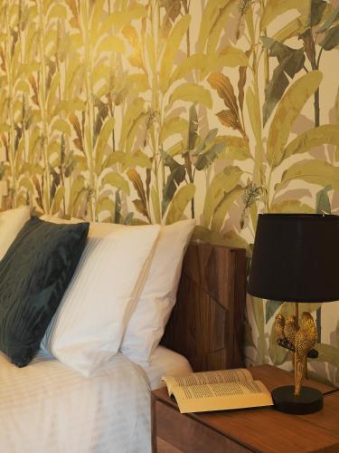 a bed with a table with a lamp and a book at Cifilì House of Charme in Catania