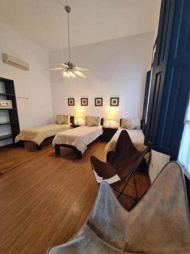 a room with two beds and a chair in it at Posada El Capullo in Colonia del Sacramento